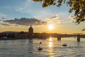 Obraz premium Golden sunset over Garonne river with views on the the pedestrian Saint-Pierre bridge, Place Saint-Pierre and the Grave hospital seen from the riverside 