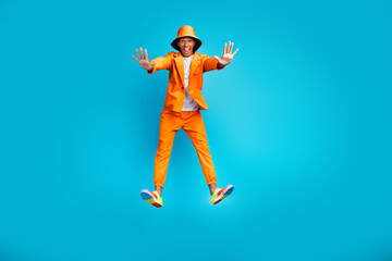 Fototapeta premium Photo of positive excited guy wave hands showing jumping wear stylish trendy suit isolated cyan color background