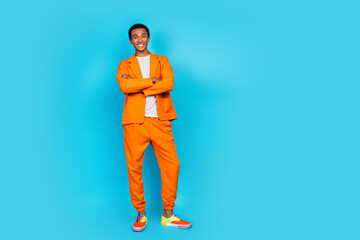 Photo of smiling posing guy cross hands wear orange suit costume isolated cyan color background