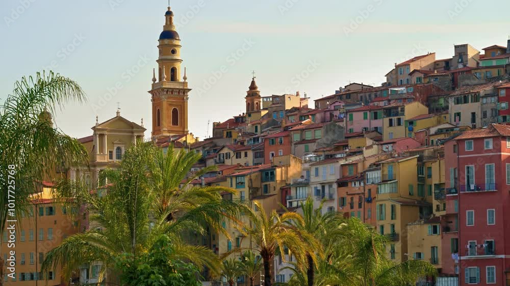 Wall mural View of palm trees with the colourful buildings in Menton, France on the background