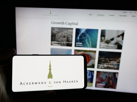 Stuttgart, Germany - 09-29-2024: Person holding smartphone with logo of Belgian company Ackermans van Haaren N.V. on screen in front of website. Focus on phone display.