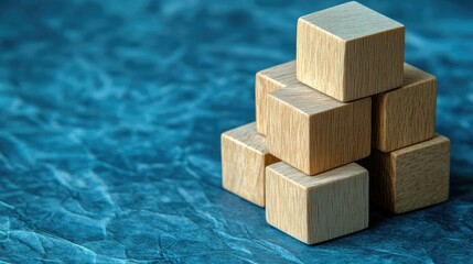 A concept of business success shown with wooden blocks arranged as steps on a blue paper background. The clean design offers space for branding or messaging.