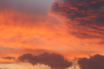 Fototapeta premium Cloudy sky and orange sun lights reflecting from clouds