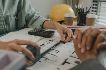 an architect and his assistant are brainstorming and examining the blueprints, two engineers are discussing a construction plan to make the structure stronger, draft, meeting, teamwork