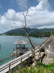 Wooden pier with gazebo overlooking tropical sea and mountains