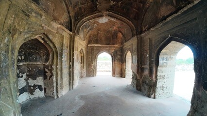 Exploring the historic architecture of an ancient Indian building with intricate arches and weathered walls at  Group Of Tombs, Jhajjar city, India 