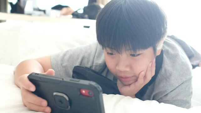 asian chinese boy playing smartphone, kid use phone and play game, addicted game and cartoon
