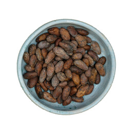 The bowl of cocoa beans. Cocoa beans in a handmade pale blue ceramic bowl isolated. Top view. 