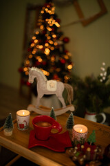 Children's toy wooden horse
 Against the background of a Christmas tree with coffee with lights on