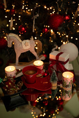 Children's toy wooden horse
 Against the background of a Christmas tree with coffee with lights on