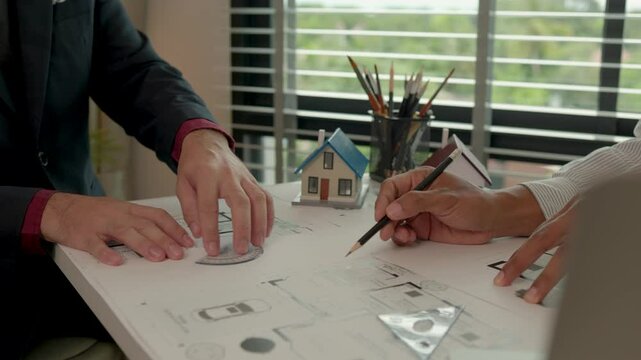 Two engineers are having a meeting about a problem have made the proportions of the house unsafe, architect and contractor are having a final meeting before finalizing the blueprints for construction.