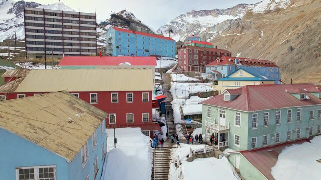 Drone Fly Sewell Chile Colorful residential houses above snowed Cordillera mountain