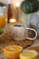 Pumpkins, various food and drinks, fall decorations, books and candles on the table. Fall hygge at home. Selective focus.