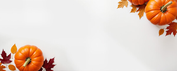 Orange pumpkins and fall leaves on a flat white background. Concept for Thanksgiving, Harvest Festival or Halloween celebrations. Autumn flat lay banner with copy space for text or product display.