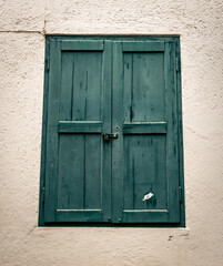 A minimalist image of old green wooden window shutters.