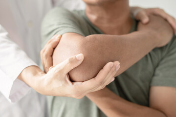 Female physiotherapists provide assistance to male patients with elbow injuries examine patients in rehabilitation centers. Physiotherapy concepts