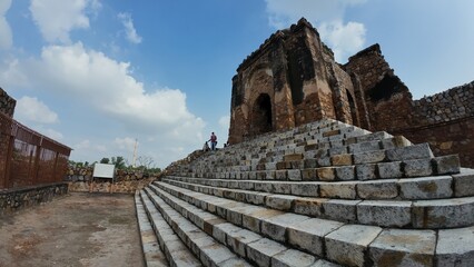 medieval structure amidst lush greenery at Feroz shah kotla fort, Delhi, India