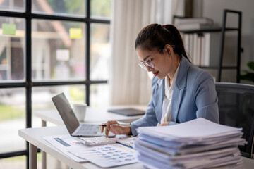 Asian accountant woman working with calculator, laptop and documents at office, doing planning...