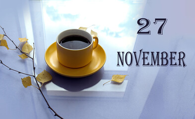 Calendar for November 27: numbers 27, name of the month, yellow November mug, autumn leaves on a pastel background