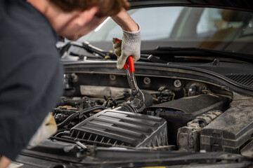 Auto mechanic working on car engine. Work on the engine in the garage