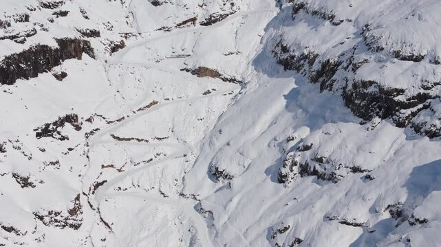 Aerial view of Sani Pass and Sani top village under fresh blanket of white snow. Tilt up and slow forward flight