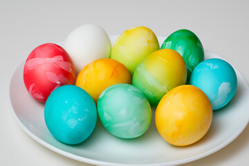 Obraz premium White eggs on a plate for easter. Food holiday spring concept. A plate of colorful eggs for easter. A plate of colorful eggs on a white for lifestyle easter.