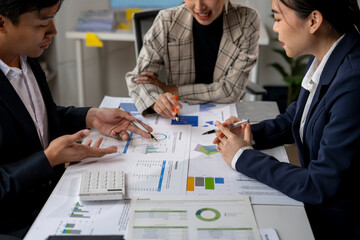 Three people are sitting at a table with papers and calculators