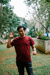 Southeast Asian man making an 'OK' gesture with his fingers, symbolizing approval or agreement