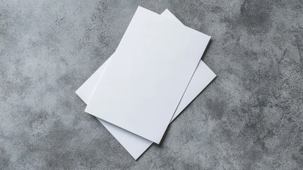 Top view of blank white brochures on a neutral surface, modern minimalist style, crisp and clean paper, ideal for advertising and print material mockups