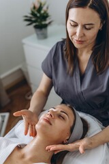 A beautiful woman enjoys a facial massage at a spa salon,indulging in skin and body care treatments.