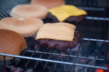 Grilling beef stakes with cheese for cheese burgers