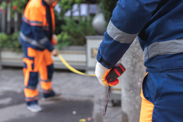 A municipal worker in uniform renews the road lines