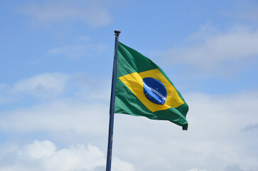 Flag of Brazil fluttering in the wind. In the center of the flag with the words 