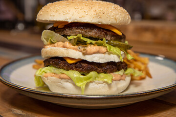 A classic home made burger on a plate placed on a wooden table