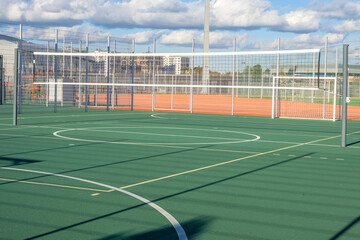 Outdoor volleyball stadium. Outdoor sports ground. Place for children football competitions. Volleyball net located above stadium. Sports ground in sunny weather. Stadium for summer sports training