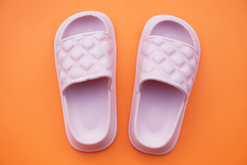 Pairs of pink rubber slippers, shoes for easy day wearing and walking, isolated on orange background. concept, fashion shoes , light and comfortable.      