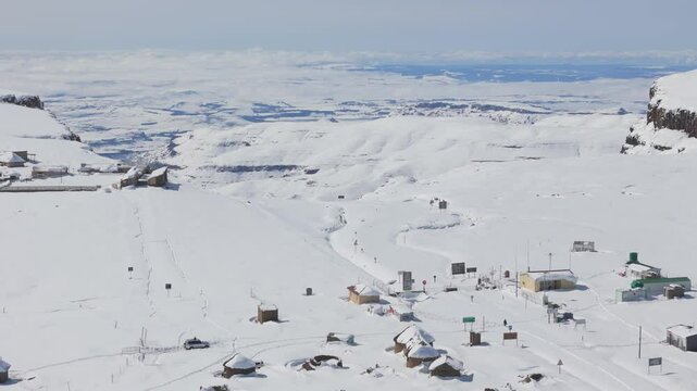 Tilt down to reveal Sani mountain pass below cliffs enveloped in thick snow
