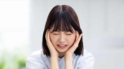 頭を押さえて悩む若いビジネスウーマン