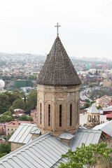 Obraz premium A historic church tower Norashen with a cross rises above the rooftops, Tbilisi, Georgia - 10 September, 2024
