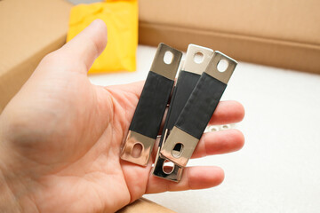 Mans hand with copper bus bar for lifepo4 prismatic cell battery