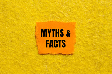 Myths and facts message written on ripped torn orange paper piece with yellow background. Conceptual myths and facts symbol. Copy space.