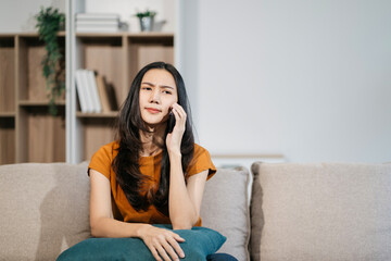 Obraz premium lifestyle Happy woman speaking to mobile phone at home. women speak with remote friend using phone. sitting on sofa.