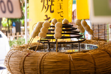 Grilled Mitsufuku Dango Skewers Being Prepared at a Street Stall (With the Vertical Sign of "Grilled Dango"), Kamakura, Japan, August 2024