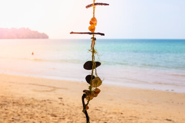 Obraz premium Seascape. Decoration on a tree, thread with shells, on the shore of a tropical island