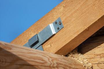 Wooden house is under construction. Sliding fastening of rafters