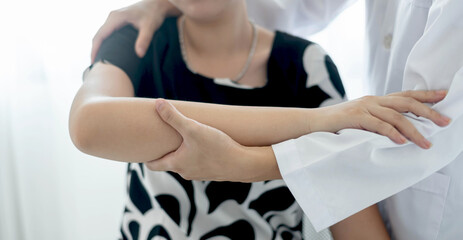 Obraz premium Female physiotherapists provide physical assistance to women patients with elbow injuries examine patients in rehabilitation centers. Physiotherapy concepts