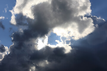 A Dramatic Scene Featuring Dark And Bright Clouds Against A Blue Sky, Conveying A Sense Of Wonder...