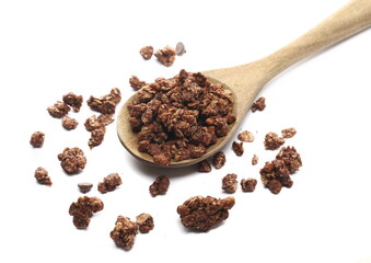 Crunchy granola, muesli pile with chocolate in wooden spoon isolated on white background, side view