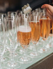 Alcohol setting on catering banquet table, bartender pouring liquor beverages, row line of different colored alcohol drinks on a party, glass of wine, sparkling wine on decorated banquet table event
