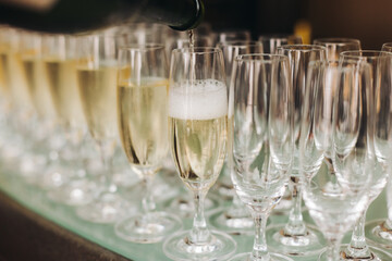 Alcohol setting on catering banquet table, bartender pouring liquor beverages, row line of different colored alcohol drinks on a party, glass of wine, sparkling wine on decorated banquet table event